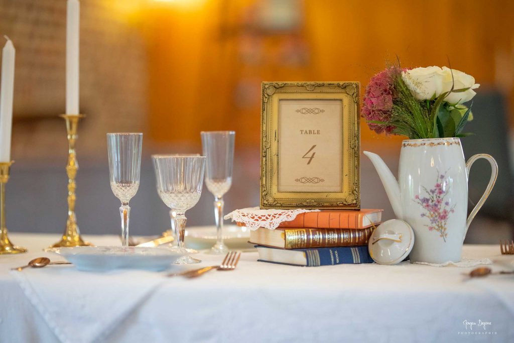 Mise en place d'une table de mariage avec décoration, porcelaine et fleurs