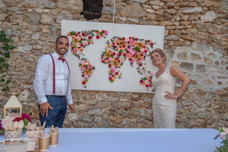 Céline et Julien montrant une map monde fait par eux avec des fleurs sur une toile blanche