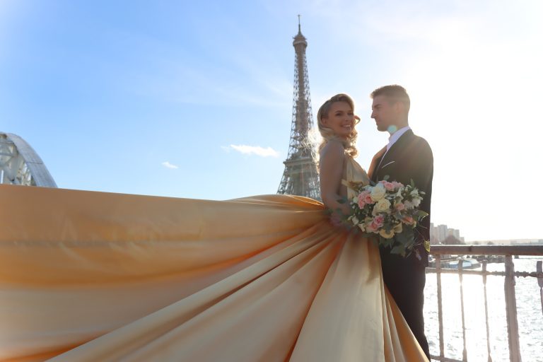 Jeunes couple mariée avec une robe dorée et une longue traine
