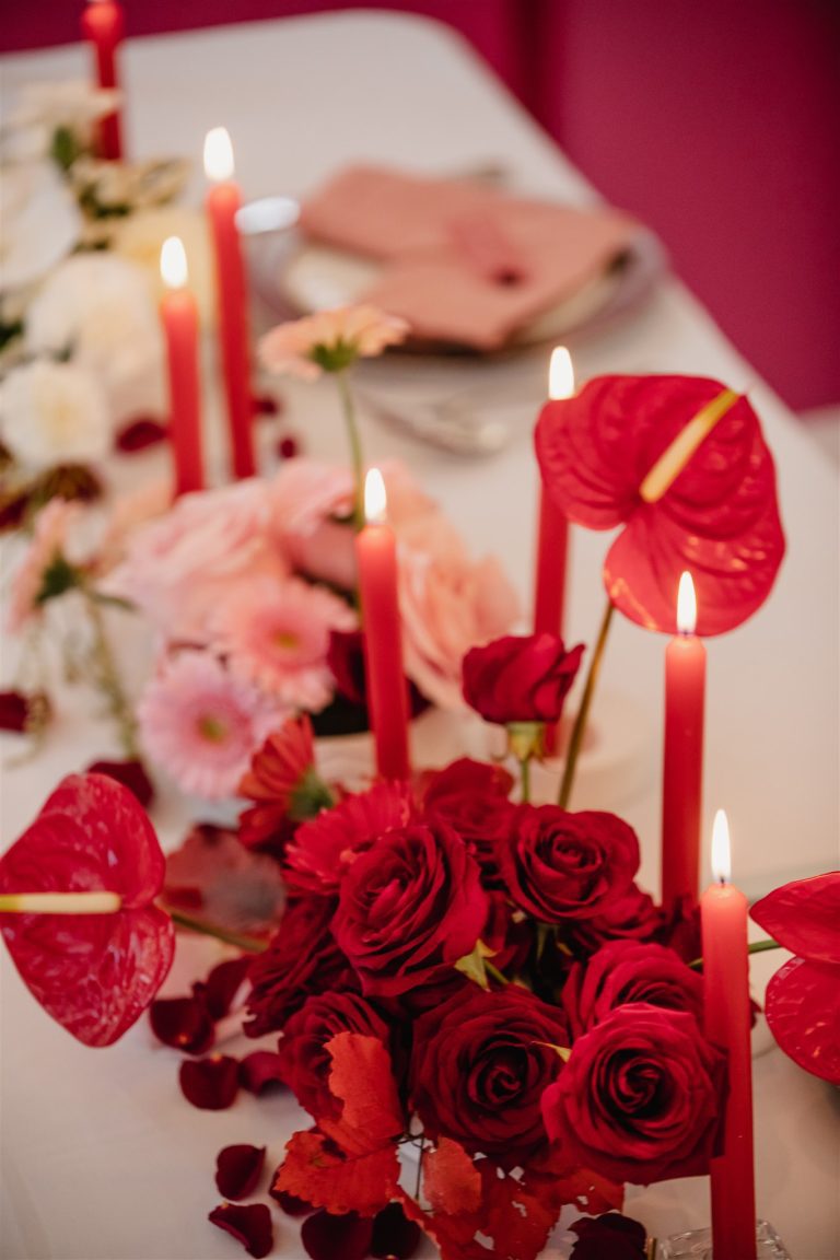 Fleurs rouges accompagné de bougies de la même couleurs