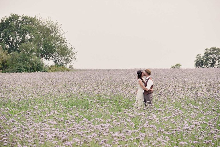 couple de mariés dans un champ de fleurs éco responsable français
