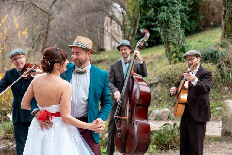 Couple en train de danser avec en second plan le groupe musicale qui composent.