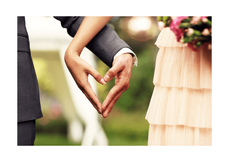 Couple de mariés formant un cœur avec leurs mains, symbolisant leur amour.