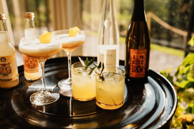 verre a cocktails sur une table avec une bouteille de jus ou d'alcool tout dans les tons noir et jaune