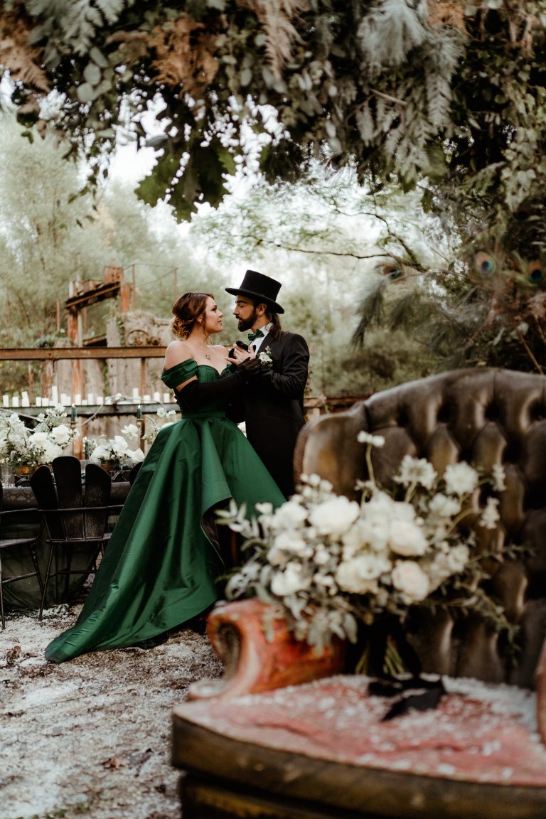 Couple en tenue de soirée élégante, partageant un moment intime dans un cadre verdoyant.