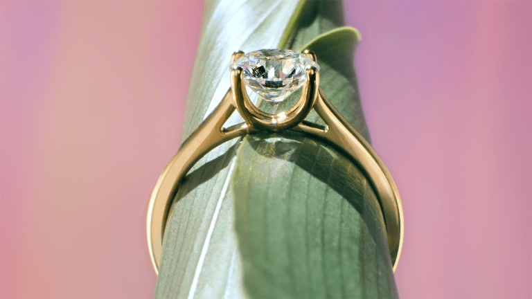 Bague de fiançailles Courbet sur une feuille verte.