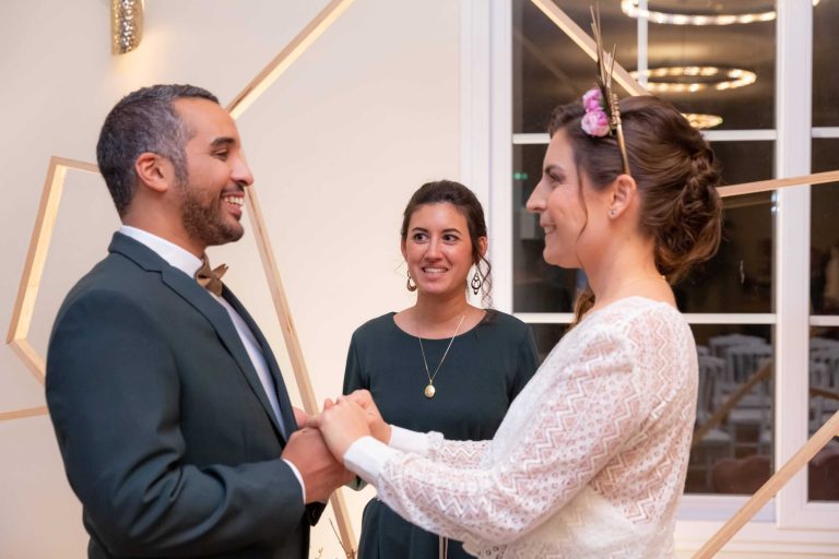 Couple souriant à l'officiante pendant la cérémonie.