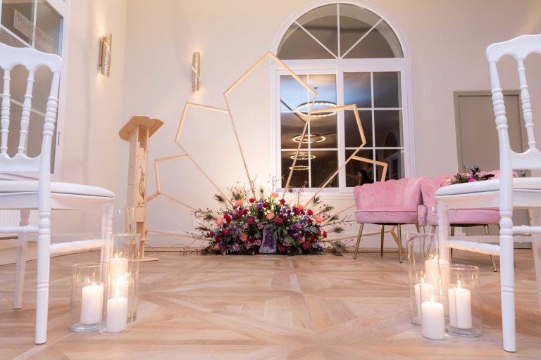 Décoration élégante de la salle de cérémonie avec des fleurs et des chaises blanches.