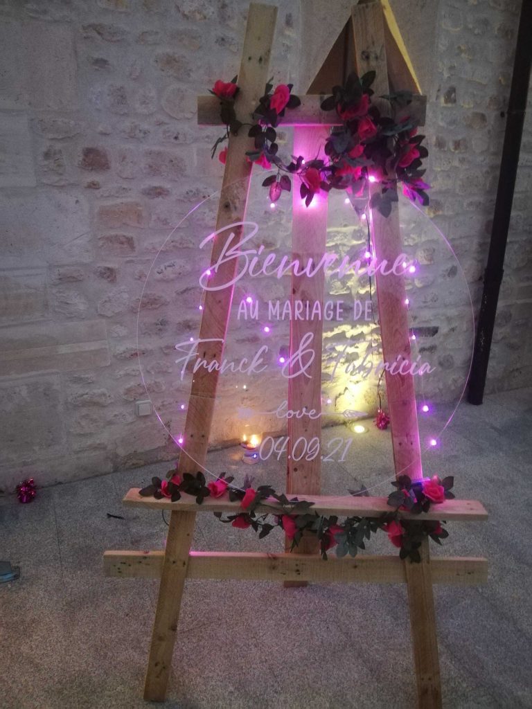 Panneau de bienvenue illuminé par un néon pour le mariage de Franck et Patricia, orné de fleurs.