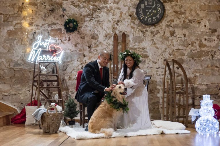 Couple marié posant avec leur chien devant un décor 'Just Married'" Titre: "Famille unie dans la célébration