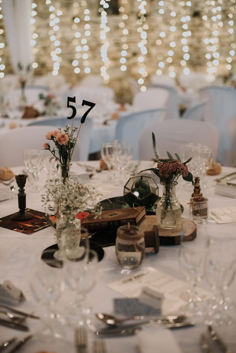 Décoration de table de mariage éclairée par des guirlandes lumineuses, créant une ambiance féerique.