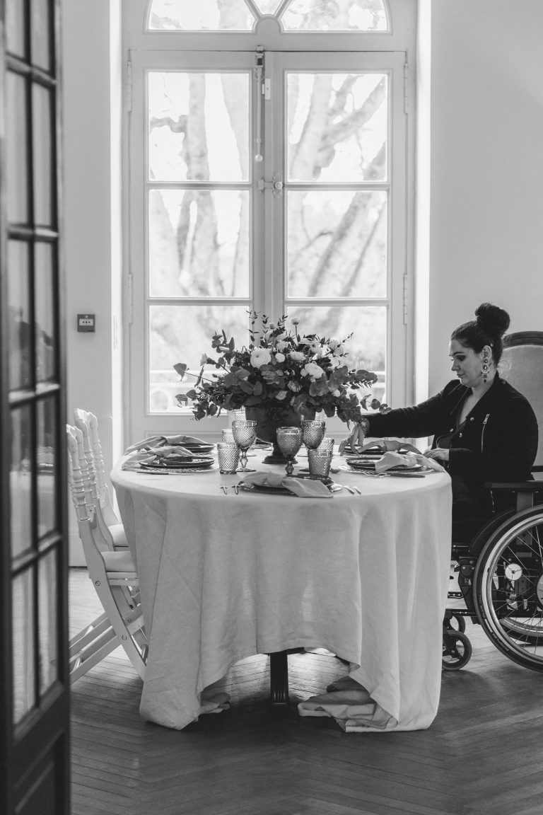 Planificatrice en fauteuil roulant vérifiant les arrangements de table