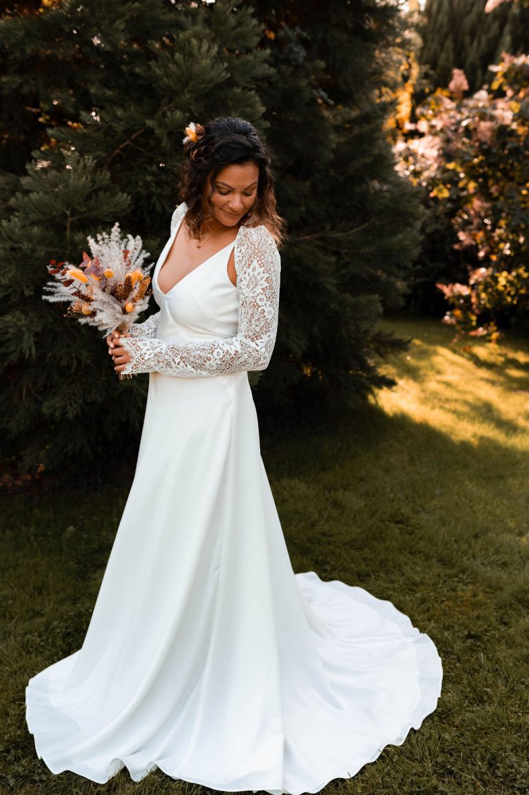 La mariée tenant un bouquet bohème dans un cadre naturel.