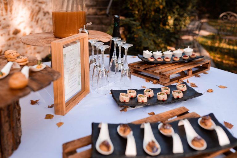 Buffet de cocktail avec une variété d'amuse-bouches et une fontaine de punch sur une table décorée.