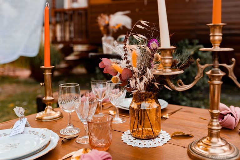 Table de mariage décorée dans un style bohème avec des fleurs séchées et des chandeliers.