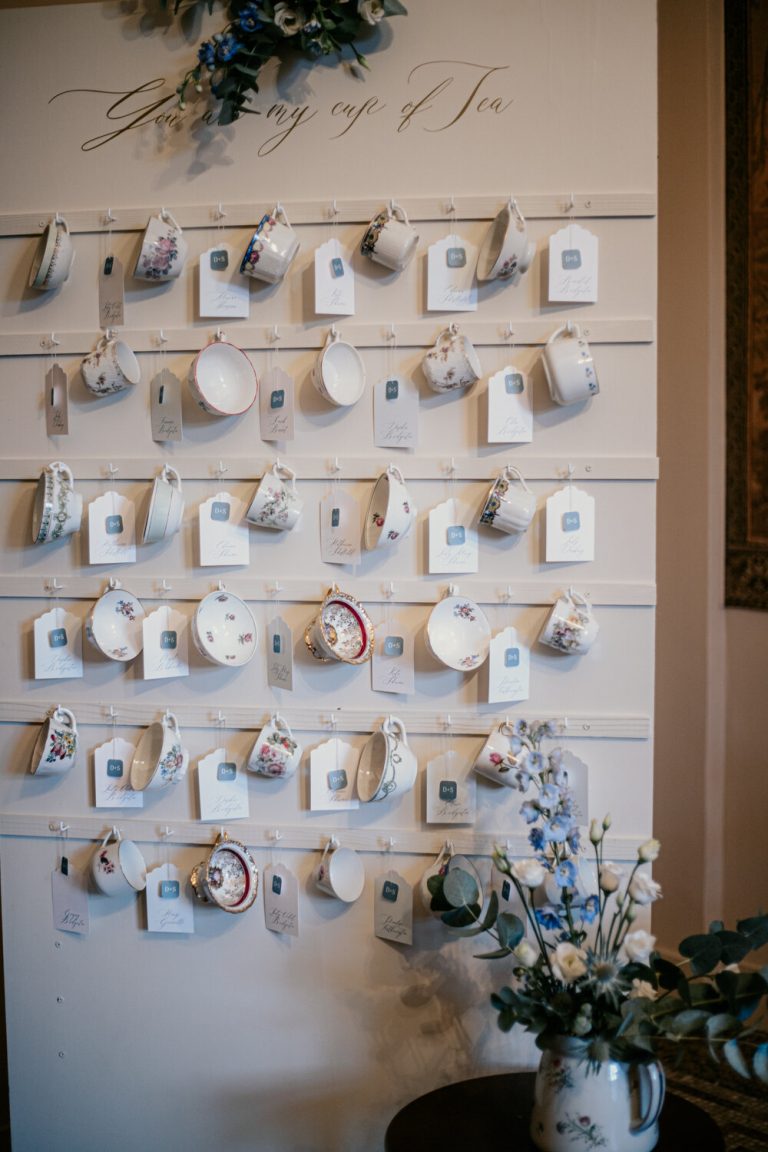 Vue détaillée du plan de table de mariage créatif, avec des tasses à thé servant de marque-places pour les invités.