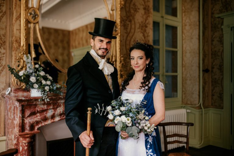 Un couple en tenue d'époque 'Bridgerton' pose élégamment dans un salon classique, incarnant le charme du 19ème siècle.