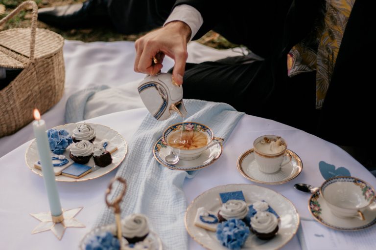 Marié versant du thé dans une tasse lors d'un pique-nique de mariage élégant.
