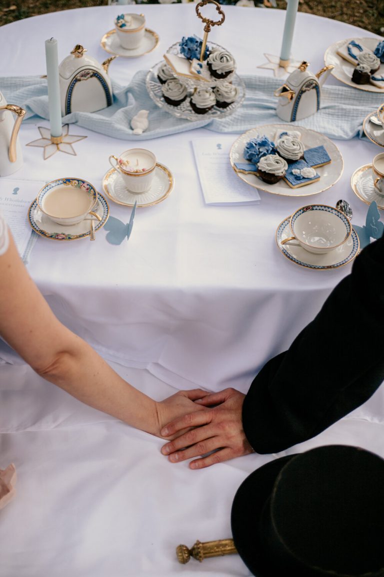 Mariés tenant main dans la main sur une table de pique-nique élégamment dressée.