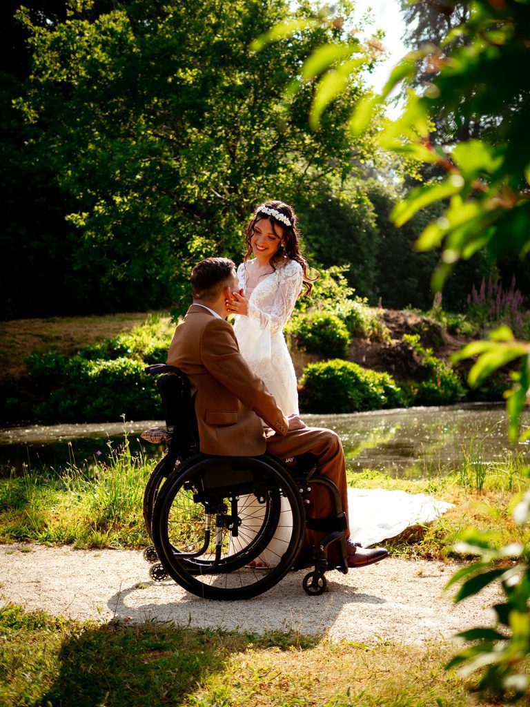 Mariés partageant un moment intime au bord de l'eau, marié en fauteuil roulant
