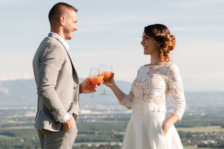 Couple de jeunes mariés trinquant avec un cocktail orange avec une vue dégagée