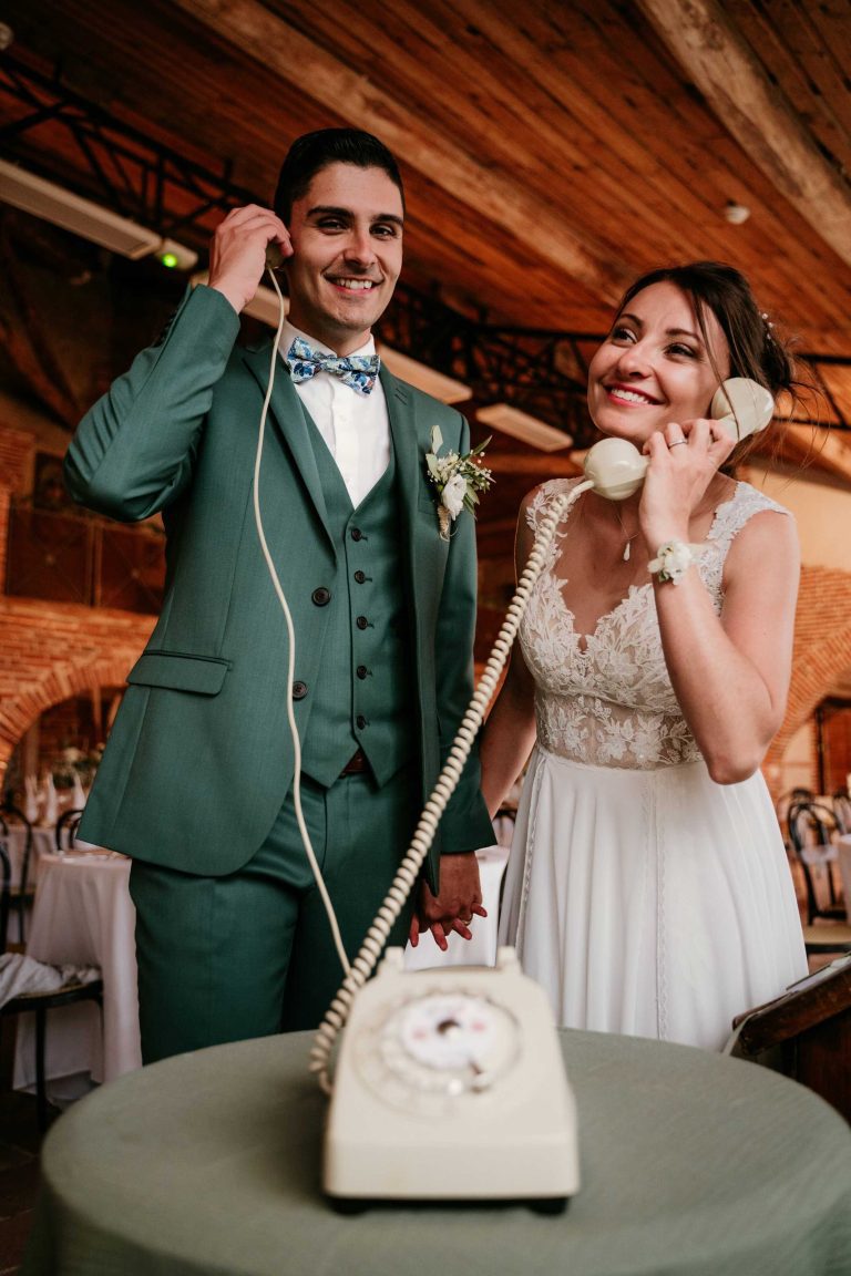 Couple riant tout en enregistrant un message audio à leur mariage.