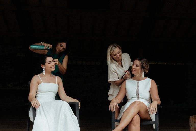 Deux mariées se préparant pour le mariage, aidées par des amies.