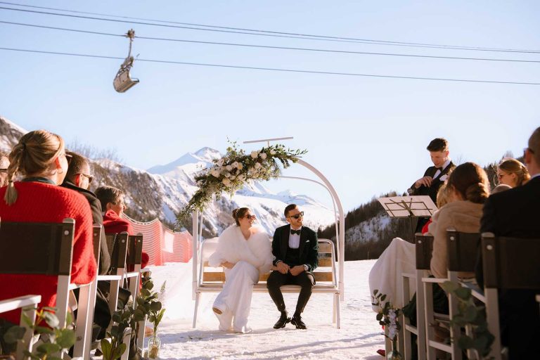 Cérémonie de mariage en plein air dans un lieu de réception à la montagne, sur fond de sommets enneigés